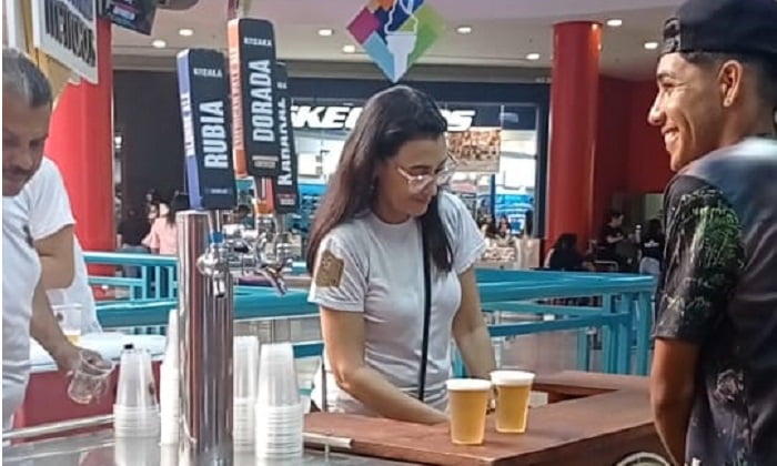 Una mujer en una barra entrega cervezas a un cliente en el Oktoberfest de Metropolis Valencia