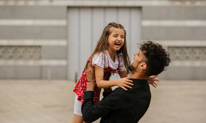Un padre cargando a su hija muy feliz de estar con su papá